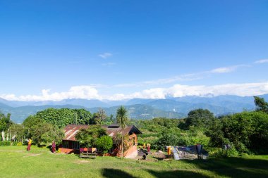 Rinchenpong, Sikkim, Hindistan - 18.10.2016: Rinchenpong Manastırı 'ndaki yurdunda kırmızı elbiseli Budist rahipler ve çocuklar. Arka planda mavi gökyüzü ve Himalaya Dağları.