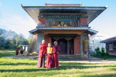 Rinchenpong, Sikkim, Hindistan - 18.10.2016: Rinchenpong Manastırı önünde kırmızı elbiseli Budist rahipler ve çocuklar. Çocukluk sevinci. Arka planda Himalaya Dağları.