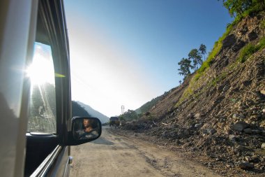Sikkim, Hindistan - 15.10.2016: Sikkim yolu üzerindeki Himalaya dağlarında yeniden inşa edilmiş yoldan geçen araba. Küresel ısınma, şiddetli yağış ve iklim değişikliğinin etkileri.