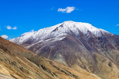 Karlı Himalaya tepeleri, Chang La 'da mavi gökyüzü, güney geçidi, Ladakh' ta yüksek dağ geçidi Büyük Himalaya 'da Leh ve Shvar Nehri vadisi arasında. Leh 'den Pangong Gölü yoluna. Leh, Ladakh, Hindistan.
