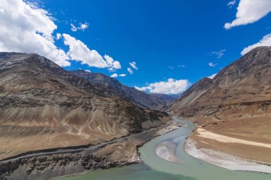 Sangam olarak bilinen İndus ve Zanskar nehirlerinin kesişiminin manzarası NH1 'deki Leh-Srinagar otoyolu boyunca Nimmu köyü yakınlarında yer almaktadır. Leh, Ladakh, Hindistan.