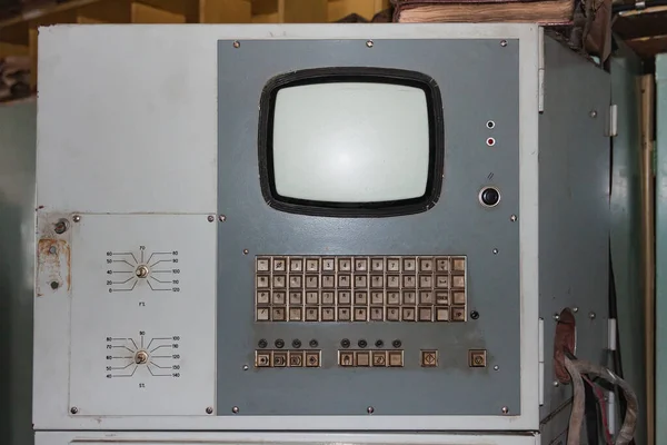 Old factory computer with a lamp monitor and keyboard in English and Russian.