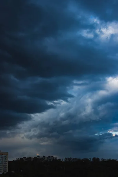 Dramatic dark cloudy sky over the horizon, natural blue background.