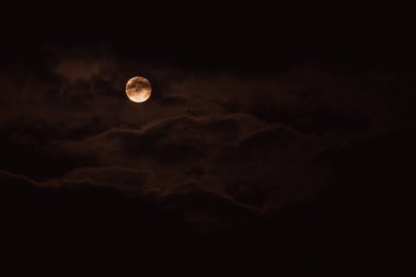Süper Ay. Bulutlu ve parlak dolunaylı gece gökyüzünün çekici bir fotoğrafı. Güzel bir dolunay ile gece gökyüzü.