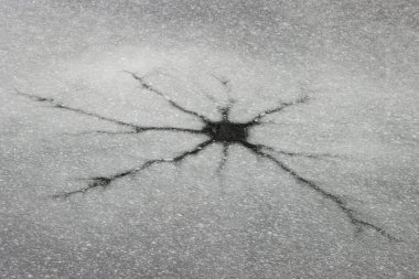 Buz ve kar kaplı göl yüzeyinde buz kalınlığı, delikler ve çatlaklar ışınlar şeklinde, kış su yüzeyi.