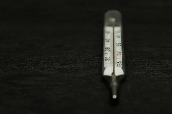 水銀古典的な体温計黒の質感の背景に横たわって 摂氏度 — ストック写真