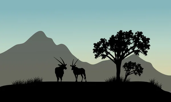 Силуэт антилопы в горах — стоковый вектор