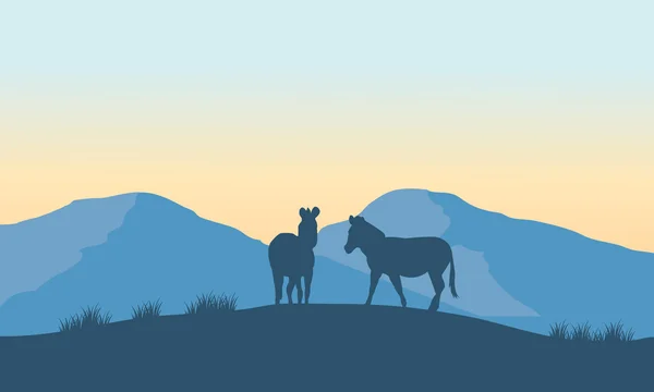 Dos siluetas de cebra en la montaña — Vector de stock