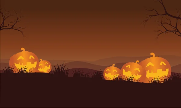 Silueta de calabazas de Halloween naranja en las colinas — Vector de stock