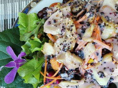 Sağlıklı gıda meyveleri ve sebze salatası, yabanmersini, ejderha meyvesi, domates, mantar, haşlanmış patates, haşlanmış fasulye ve beyaz tabak soslu salatalık. Mor çiçek süslemesi.