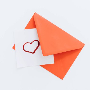 Kompozisyon kırmızı bir kalp ve beyaz bir zemin üzerinde bir zarf. Üst manzara, düz yatış. Aşk, dostluk ve bir aşk ilanı. Sevgililer Günün kutlu olsun. Kadınlar Günü. Asgari, şık tatil konsepti.