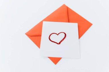 Kompozisyon kırmızı bir kalp ve beyaz bir zemin üzerinde bir zarf. Üst manzara, düz yatış. Aşk, dostluk ve bir aşk ilanı. Sevgililer Günün kutlu olsun. Kadınlar Günü. Asgari, şık tatil konsepti.