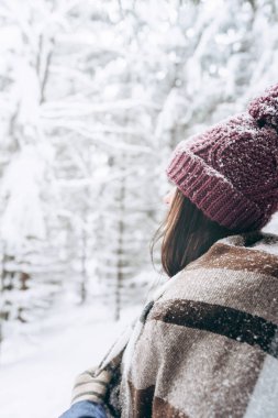 Young happy girl is enjoying the winter on a frosty day, with snow in winter Park.The winter lifestyle.Individual winter adventures.Rest during the Christmas holidays.healthy break