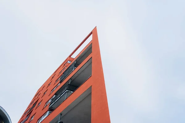 A fragment of a modern building with a geometric shape against a blue sky.Urban abstract futuristic architecture in the style of minimalism creates a geometric stylish pattern.Vertical orientation