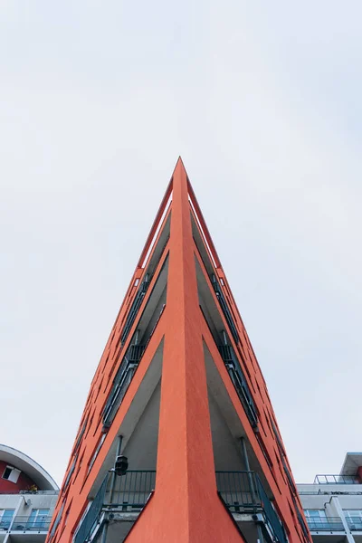 A fragment of a modern building with a geometric shape against a blue sky.Urban abstract futuristic architecture in the style of minimalism creates a geometric stylish pattern.Vertical orientation