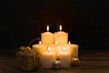 Siyah arkaplan ile yanan yedi mum grubu. Rahatlık kavramı, maneviyat, mistisizm, din, ölülerin anısı. Ölüler Günü. Dikey fotoğrafçılık ve kopyalama alanı