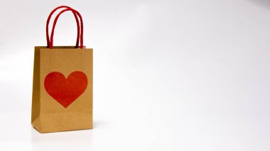 Ortasında kırmızı kalp olan bir kese kağıdı. Sevgililer Günü hediyesi konsepti. Boşluğu Kopyala