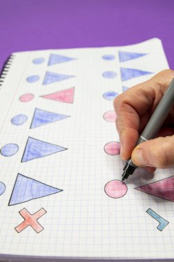 Kadın ve erkek arasındaki eşitsizliği ve eşitsizliği simgeleyen çizimlerle dolu bir defter ve bunları çizen bir el resmi. Cinsiyet eşitliği kavramı.