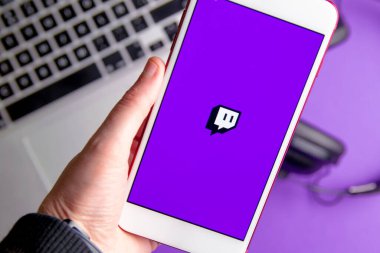 İspanya. 03, 05, 2021. Bilgisayar klavyesinde video canlı yayın platformunun logosu olan akıllı telefon ekranının kapanışı