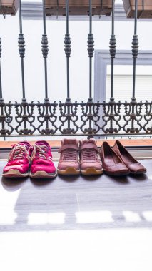 Balkon kapısında iki kadın ve bir kız ayakkabısı. Aile günlük hayat konsepti. Lezbiyen aileler, iki anne. Dünya Aile Günü
