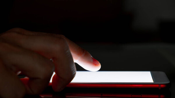 Close-up of a man using his smartphone at night. Insomnia concept. Use of mobile devices at night