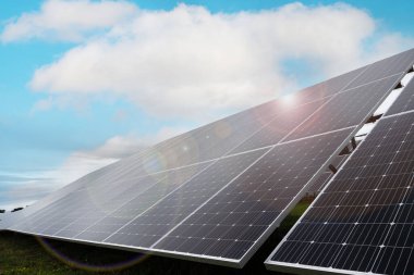 Güneş ışınlarının altındaki güneş panelleri ve mavi bir gökyüzü. Sadece enerji kavramı, eko-sürdürülebilir enerji