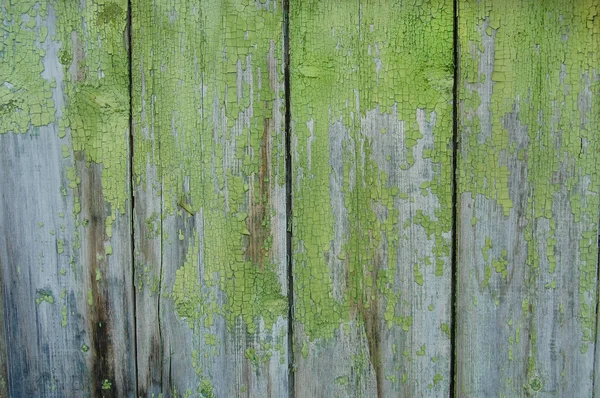 Trä shabby palisade, grön bakgrundsfärg, spruckna färg — Stockfoto
