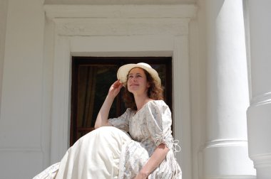 Gün ışığında oturuyor ve şapka palace yakınındaki vintage elbiseli dokunmadan Avrupa kadın. 