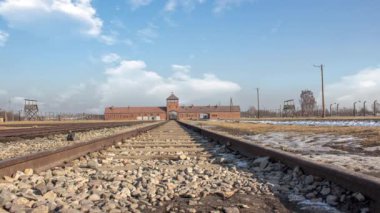 İkinci Dünya Savaşı ve Yahudi Soykırımı sırasında işgal altındaki Polonya 'daki Auschwitz toplama kampının zaman aşımı. Güneşli ve bulutlu bir günde. Tren ikilisi yakında.