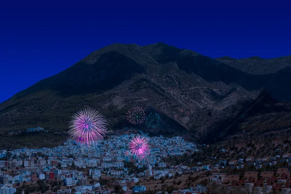 Yılın son gecesi Fas 'taki Chefchaouen köyünde yeni yıl için havai fişek gösterisi. Noel atmosferi. Mavi köy yakında, dağ da arka planda.