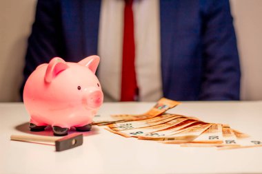 50 Euro 'luk banknotlar, kumbaralar ve çekiçler gösteren bir işadamı. Finansal ve para tasarrufu kavramı