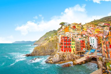Ligurya 'da Akdeniz kıyısındaki Cinque Terre' deki dağda Riomaggiore - İtalya ve güneşli gökyüzü, geleneksel İtalyan mimarisi
