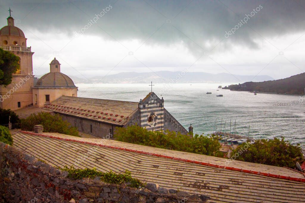 View of mediterranean sea during storm from porto venere with dome christian church in close up