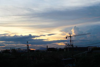 Akşam gün batımında inşaat malzemelerinin silueti. Akşam günbatımında vincin silueti