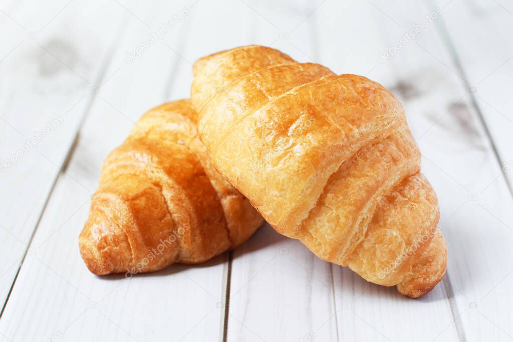 Fresh croissants on a white background,  Food and breakfast concept, puff pastry and biscuits on wooden table.