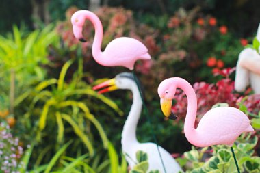 Pembe flamingo heykelinin yakın plan fotoğrafı, süs bahçesindeki pembe flamingo heykeli..