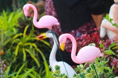 Pembe flamingo heykelinin yakın plan fotoğrafı, süs bahçesindeki pembe flamingo heykeli..
