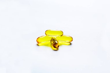 Beyaz arka plan ve doku üzerindeki balık yağı kapsülleri, balık yağı kapsülleri ve kapsül, seçici odaklanma..