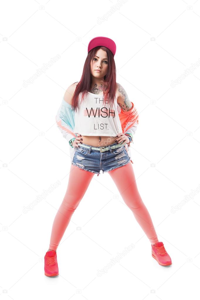 Young hip-hop swag girl in pink tight leggings, crop top and in denim shorts  with red hair. Stock Photo by ©studiomediaceh 56432357