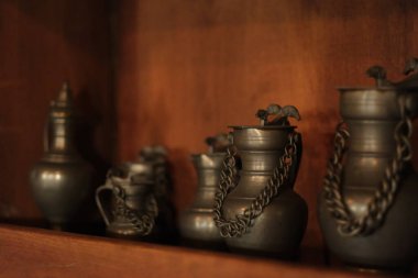 Rafta eski bakır şarap kabı var.