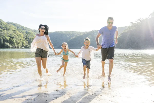 Familie uitgevoerd op strand — Stockfoto