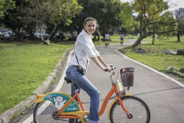 Woman with bicycle in park — Stock Photo, Image