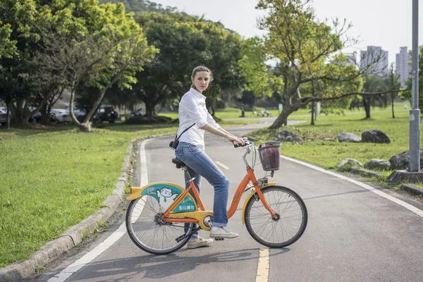 Woman with bicycle in park — Stock Photo, Image