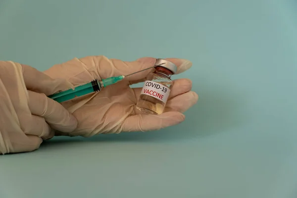 Coronavirus COVID 19 enjeksiyonu, doktorun elindeki küçük bir şişede aşı.