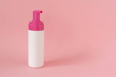 Kozmetik kremi, jel ve pembe arka planda cilt bakımı için beyaz plastik kozmetik şişesi.