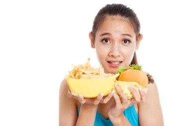Güzel Asyalı sağlıklı kız hamburger ve patates kızartması ile