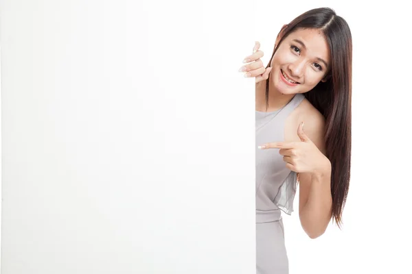 美しい若いアジア女性は空白記号の後ろに指を指す — ストック写真