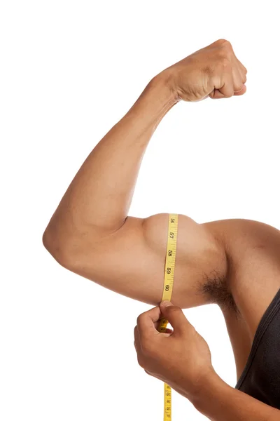 Muscular Asian man's arm flexing biceps with measuring tape — Stock Photo, Image