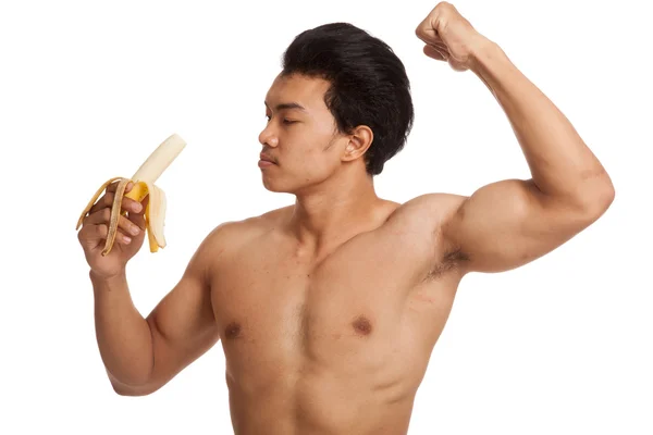 Muscular asiático homem flexionando bíceps com banana — Fotografia de Stock