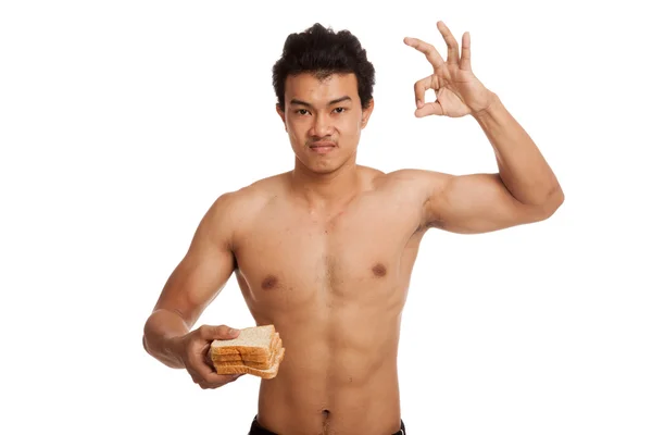 Muskulös asiatisch mann load carbs mit einige brot zeigen ok — Stockfoto